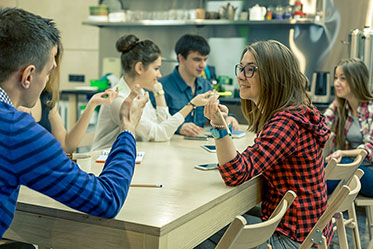 Vergrößerungsansichten für Bild: Gesprächssituation: Jugendliche und Erwachsene am Tisch.