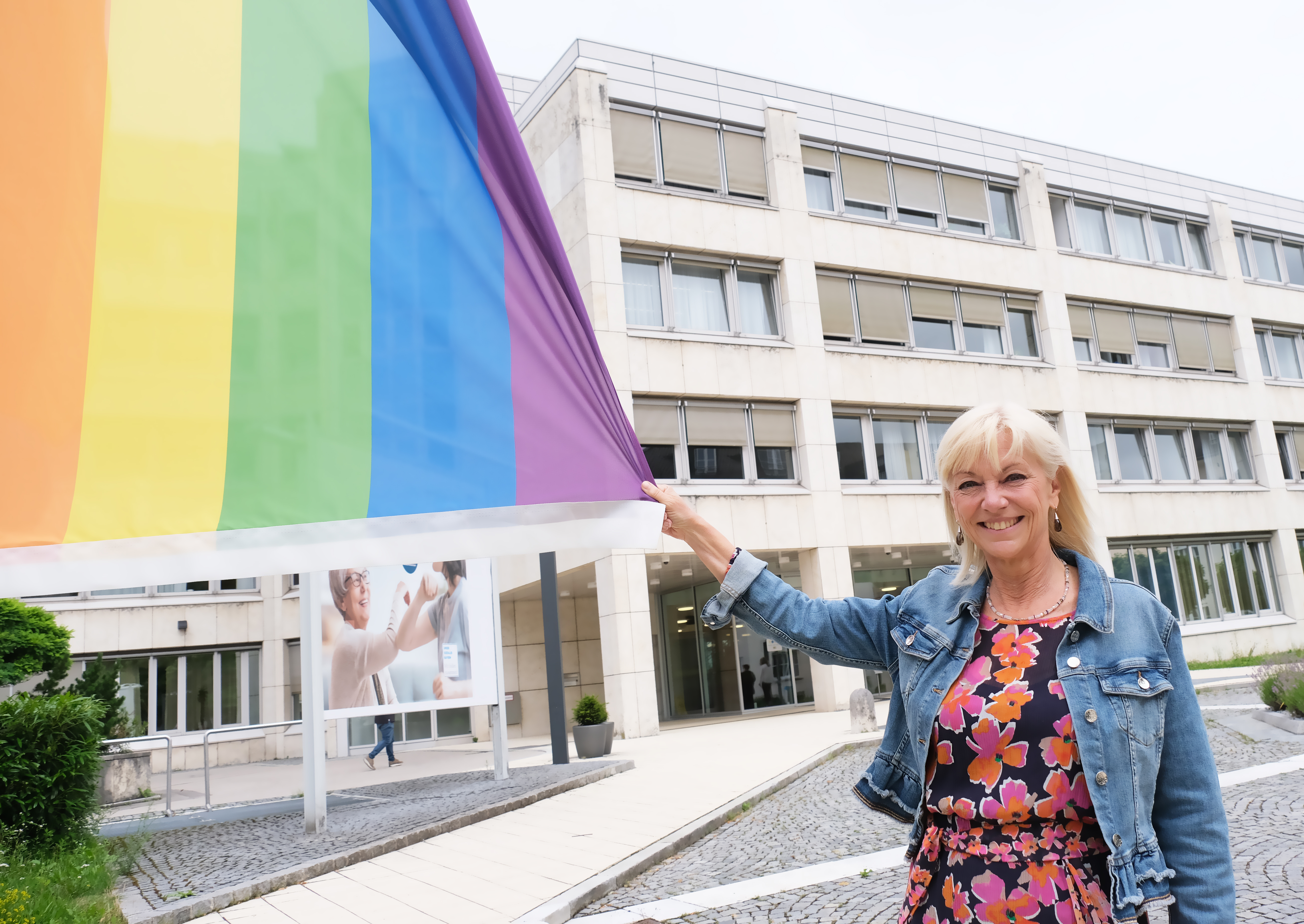 Foto Ministerin Trautner mit Regenbogenflagge vor dem StMAS